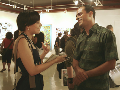 El artista mayagüezano Santiago Flores Charneco explica a Marta García, de Prensa RUM, detalles de sus obras.