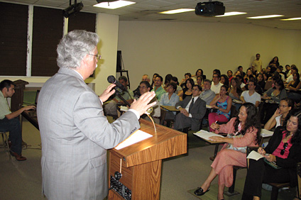 The speaker presents, to a rather largely crowded conference room, about the strengths and weaknesses of professional ethics.