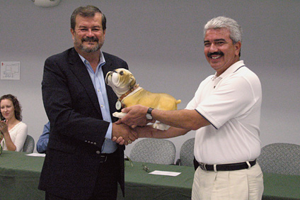 El rector del RUM, doctor Jorge Iván Vélez Arocho (a la izquierda) le obsequió al ingeniero José Font, de Boeing, una figura en cerámica de la mascota del Recinto, Tarzán.