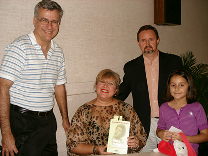 The author conversing with colleagues from the Chemistry Department; in order from left to right: Dr. Rodolfo Romañach, Dr. Vega Olivencia, and Department Director Francis Patron, accompanied by her daughter.