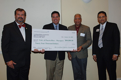 UPRM chancellor, doctor Jorge Iván Vélez Arocho, receives a symbolic check from the Lockheed Martin Vice President, Joe Petrone, for the sum of the contribution by the company for student initiatives. He is accompanied by the dean of Engineering, doctor Ramón Vásquez and Mauricio Guadamuz, also from Lockheed Martin.