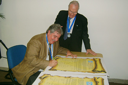 El doctor Benjamín Colucci durante la firma de una de las resoluciones de API. Lo observa el ingeniero Miguel Ángel Yadarola