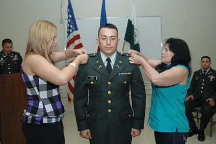 Las barras distintivas del rango son colocadas por los familiares de los cadetes. En la foto, el soldado Carlos Ruiz recibe las barras de mano de su esposa y madre.
