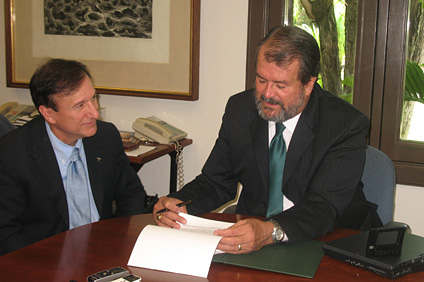 El rector del RUM, Jorge Iván Vélez Arocho (a la derecha) firma el acuerdo de colaboración con Westernbank, lo observa el licenciado Frank Stipes.