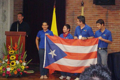 En el podio el doctor Luis Cáceres durante su mensaje de aceptación de la sede de las Olimpiadas 2010. Lo acompaña la delegación puertorriqueña.