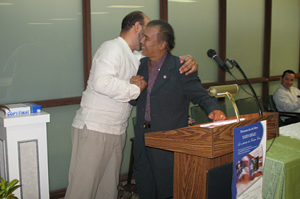 Tato Díaz recibe un abrazo del profesor López durante la presentación del libro.