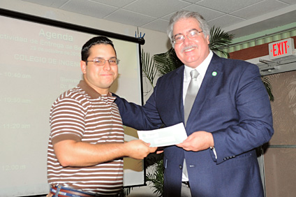 El doctor Benjamín Colucci (derecha) entrega la beca a Joshua J. León Ricardo (izquierda), de AIChE.