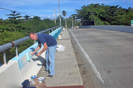 Alexis Rivera, ilustrador de Sea Grant, pinta parte de lo que será el mural en el punte del Caño Boquilla.