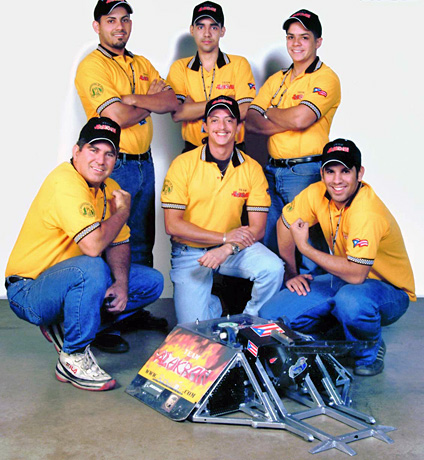 Los miembros del equipo colegial de los Rumblebots, entre los que figuraron don Pedro Sánchez, en primer plano extrema izquierda, y su hijo Jesús, en primer plano extrema derecha, cuando quedaron campeones en las Battlebots en el 2004 con su Alakrán. (suministrada)