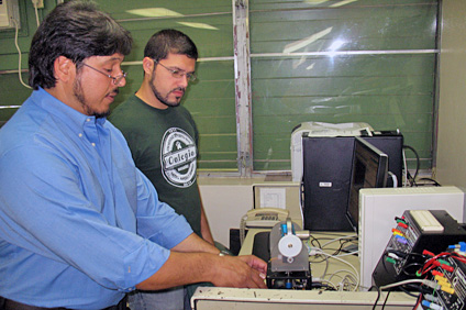 Desde la izquierda, el doctor Gerson Beauchamp muestra, junto un estudiante, uno de los equipos que se utiliza en el Laboratorio de Instrumentación y Control de Procesos.
