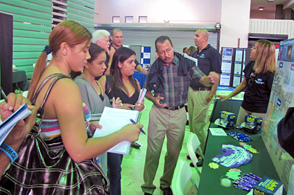 Un representante de Pfizer explica los pormenores de su proyecto a un grupo de estudiantes.