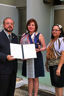 El rector interino del RUM, doctor Jorge Rivera Santos, entrega la proclama a la profesora Wanda Pérez, directora interina de la Biblioteca General y a Jacqueline Vélez, presidenta del Comité de celebración.