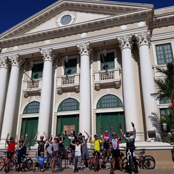Ciclistas posando con sus bicicletas frente a la Casa Alcaldía de Mayagüez.