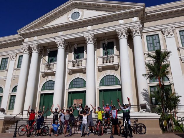 Ciclistas posando con sus bicicletas frente a la Casa Alcaldía de Mayagüez.