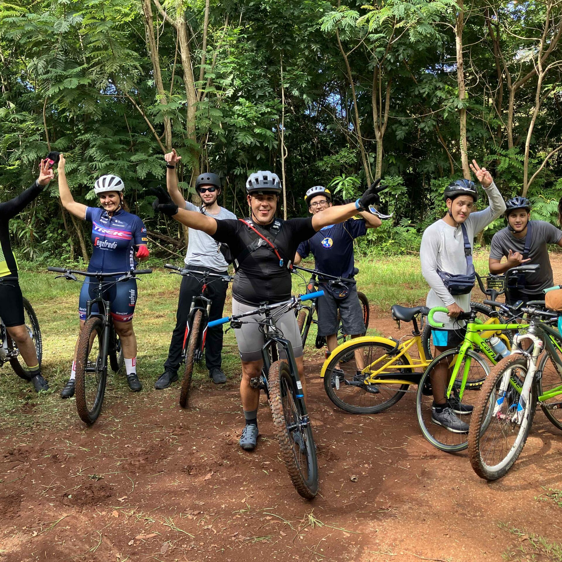 Participantes del recorrido en bicicleta en Monte Pirata con sus bicicletas saludando y levantando las manos.