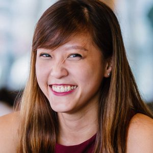 Stock photo of a young person with long hair and smiling.