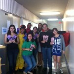 Students in different costumes holding pamphlets for the Open House.