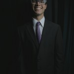 Cast member for the student presented play of The Rocky Horror Picture show wearing glasses and a tuxedo.