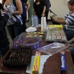 EDSA members tending to customers at the EDSA Book & Bake Sale. The table is lined cookies, cupcakes and other sweets that were for sale.