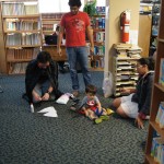 EDSA members helping a child in costume to setup his mask hile sitting on the floor.