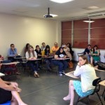 Students in the classroom sitting on their chairs listening to the presentation.