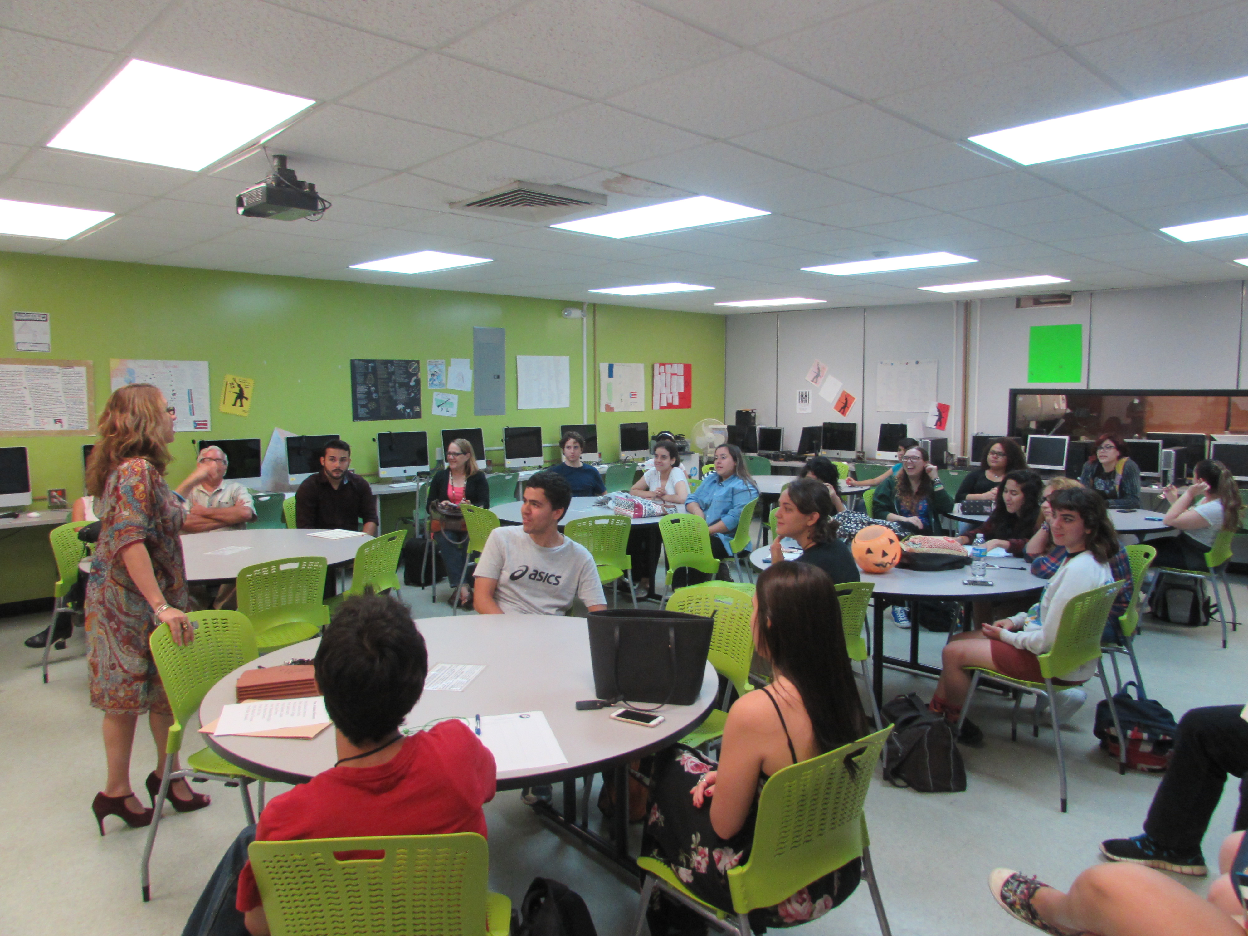 A professor is giving a presentation about the English Department Programs to a room full of students.