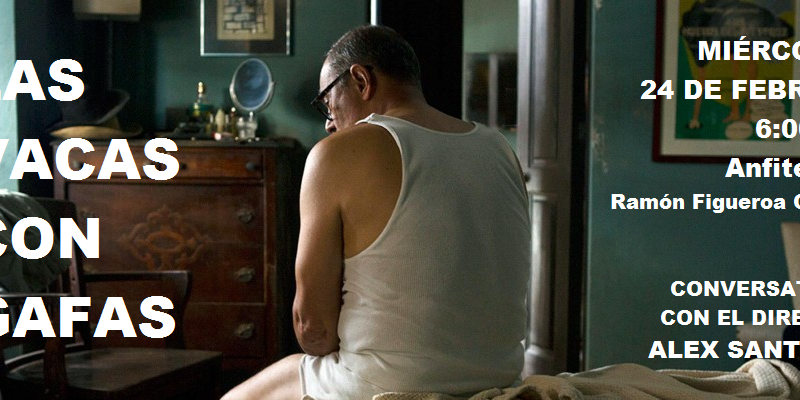 A man is sitting on a bed, looking to the side.