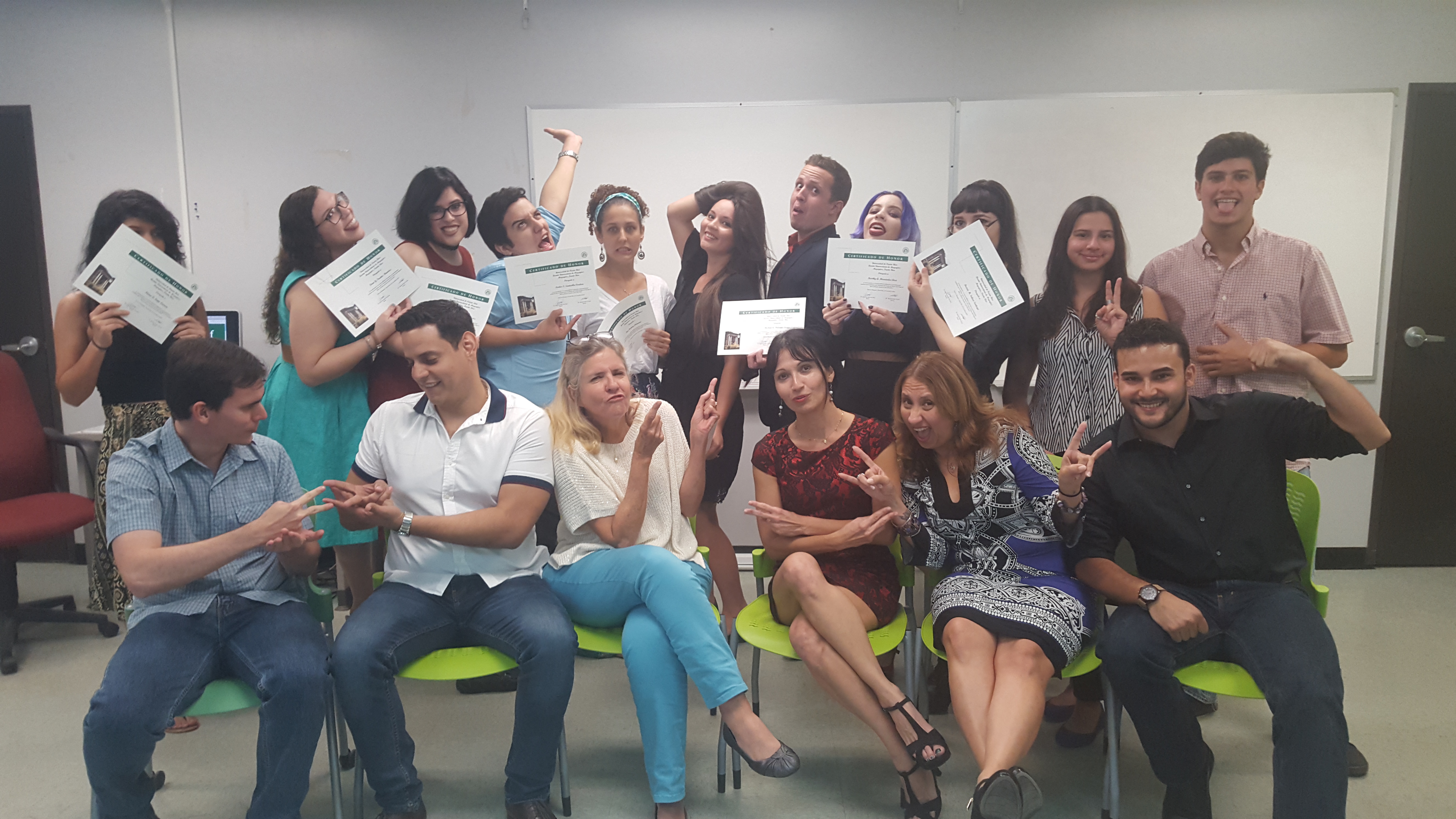 The Honor Roll Students posing for the camera while holding up their certificates (background) and the faculty members posing along with them (foreground). This time trying a funny face on.