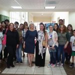 Students, members and faculty posing for the camera in a hallway.