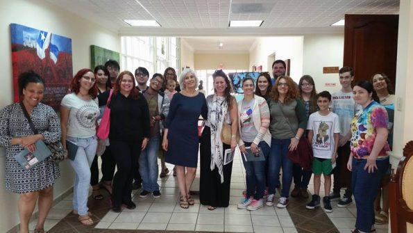 Students, members and faculty posing for the camera in a hallway.