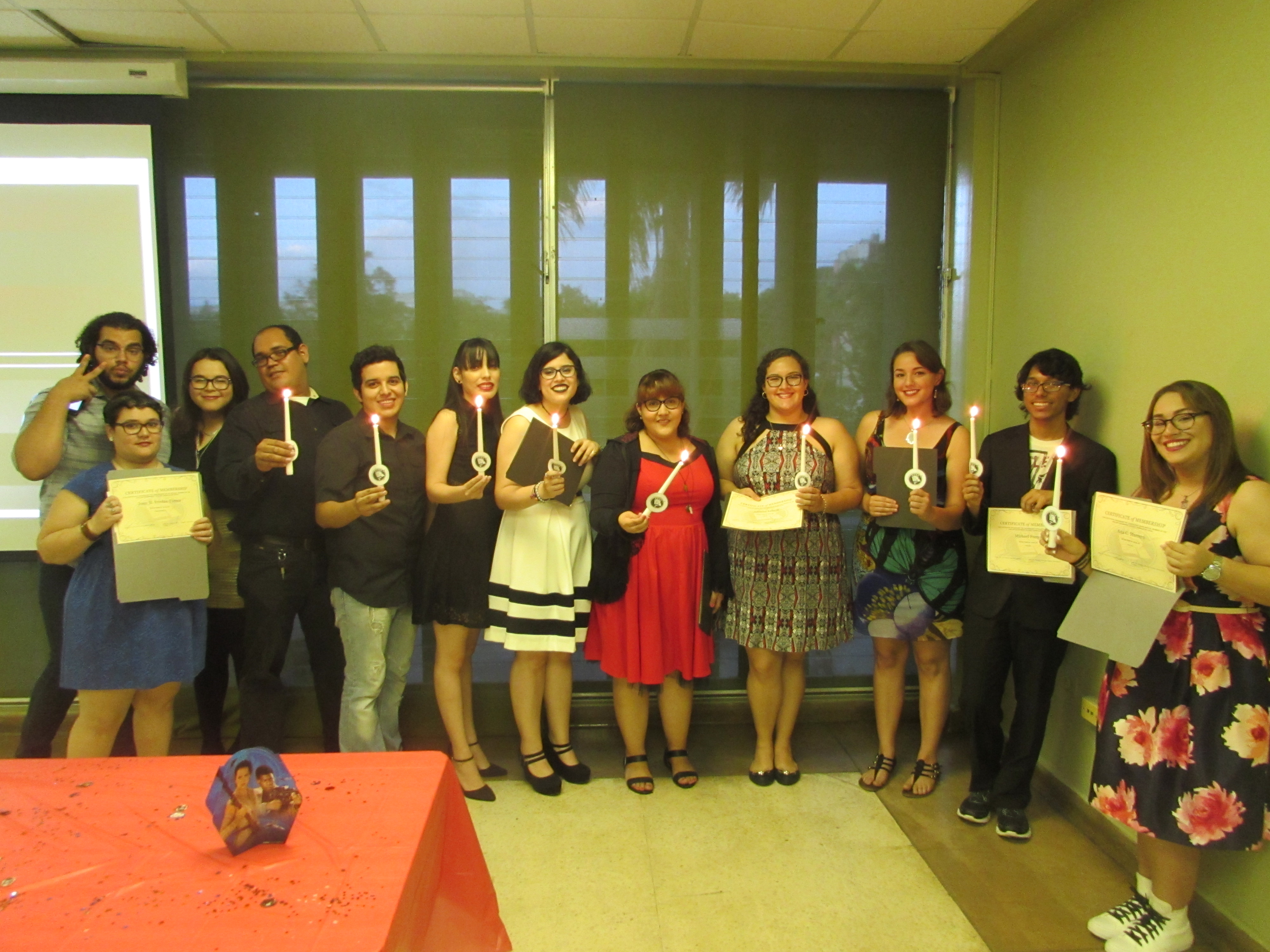 Attendants of the joint activity of May the 4th Be with you by EDSA & PCSA holding up lit candles and certificates, posing for the camera.