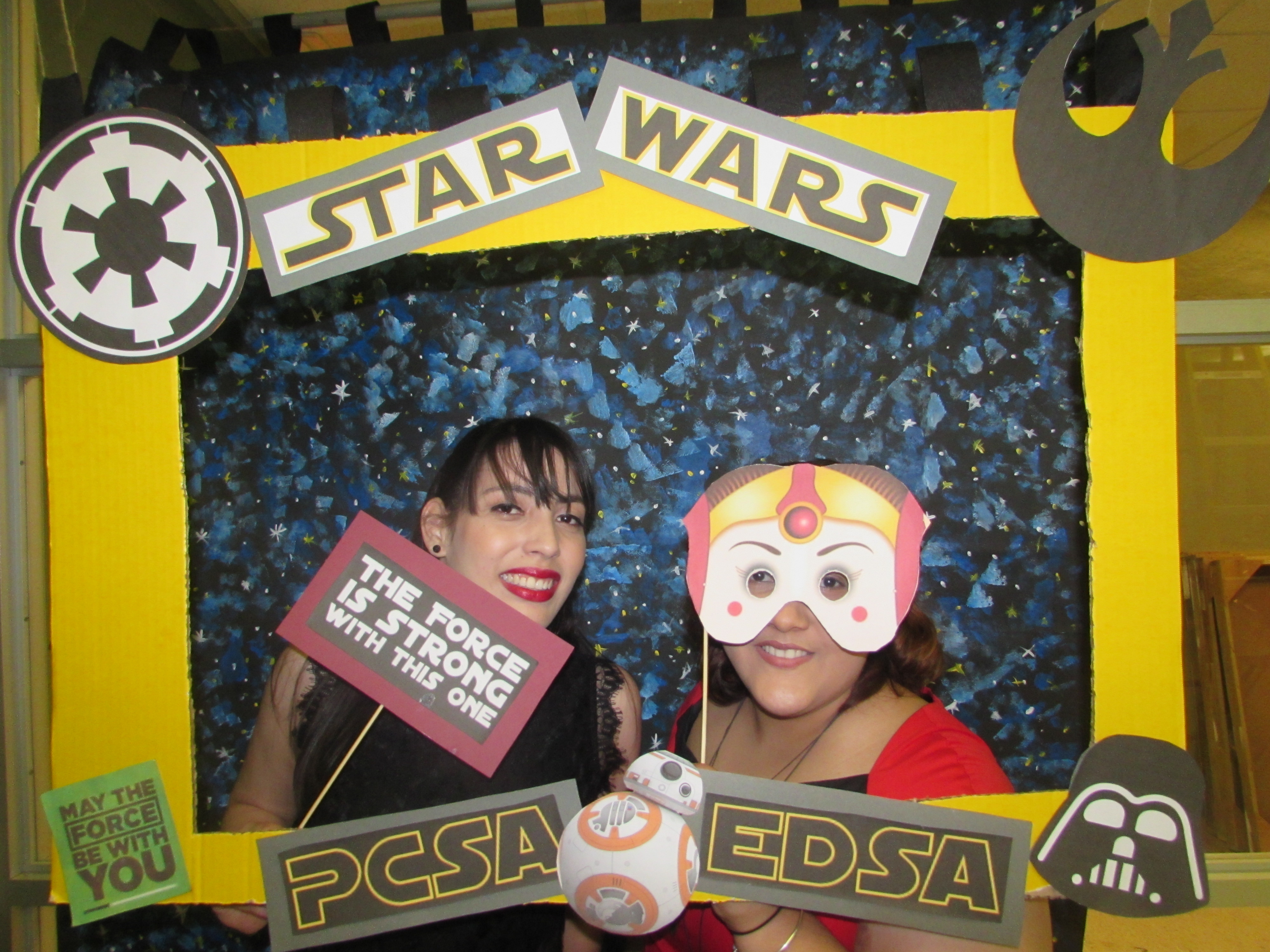 Attendants of the joint activity of May the 4th Be with you by EDSA & PCSA posing for the camera while holding up a promotional frame for PCSA and EDSA and wearing masks.