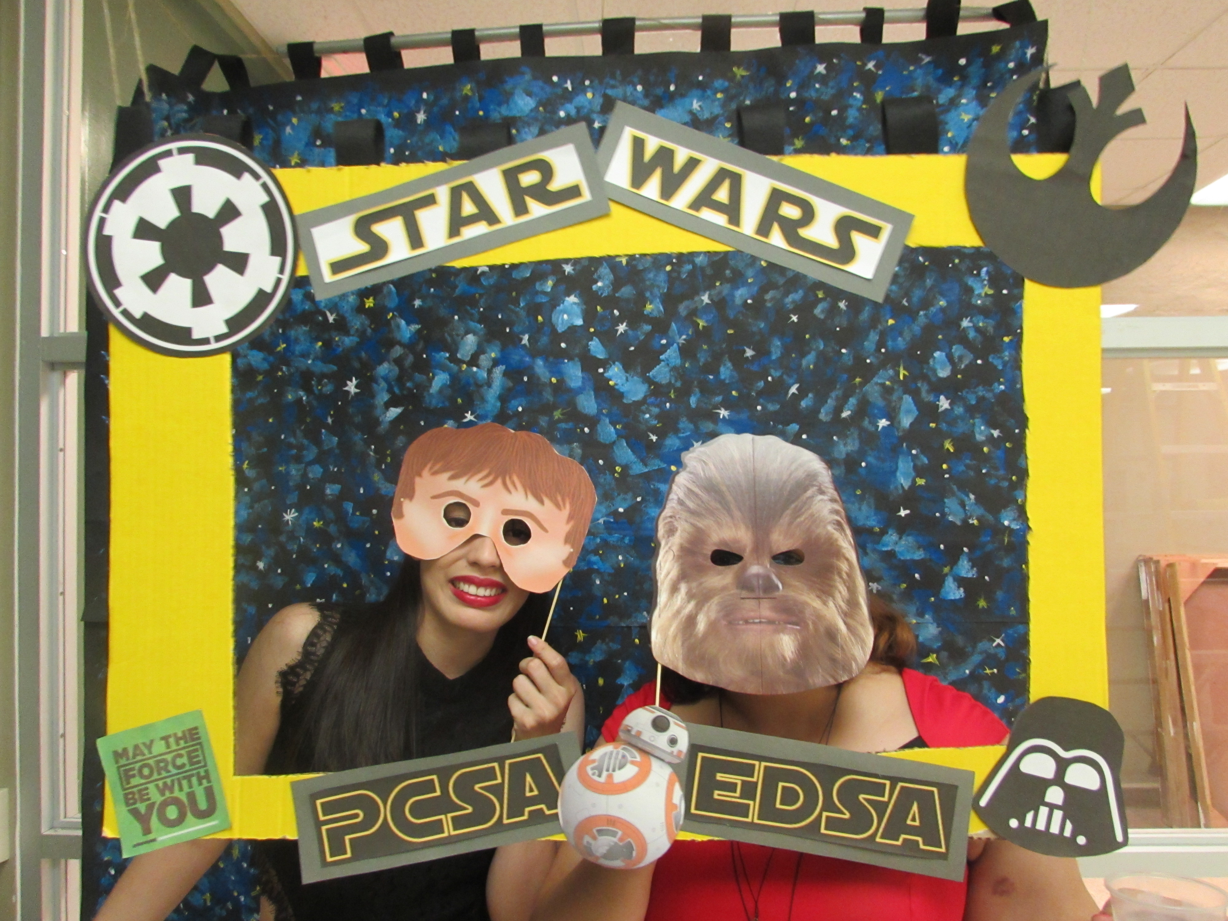 Attendants of the joint activity of May the 4th Be with you by EDSA & PCSA posing for the camera while holding up a promotional frame for PCSA and EDSA and wearing masks.