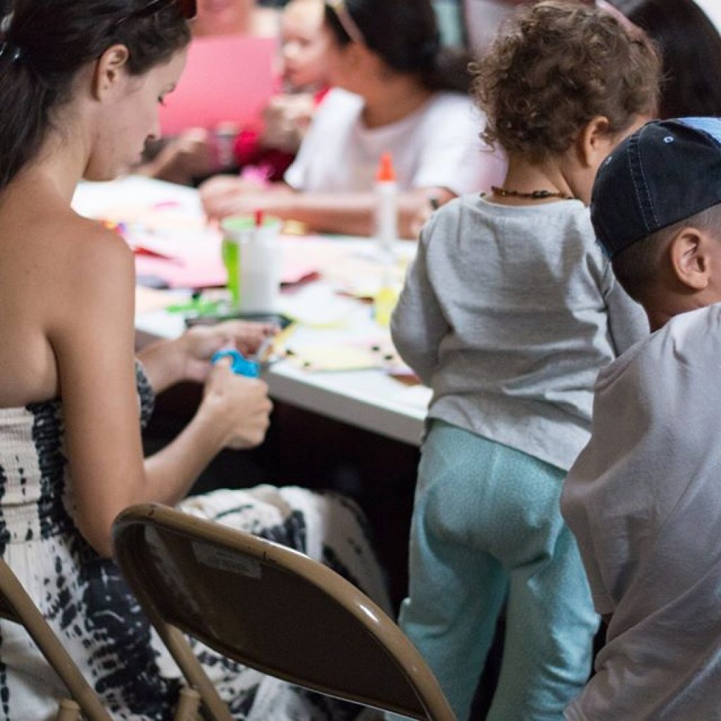 A close up of the children and the table containing the arts and craft material.