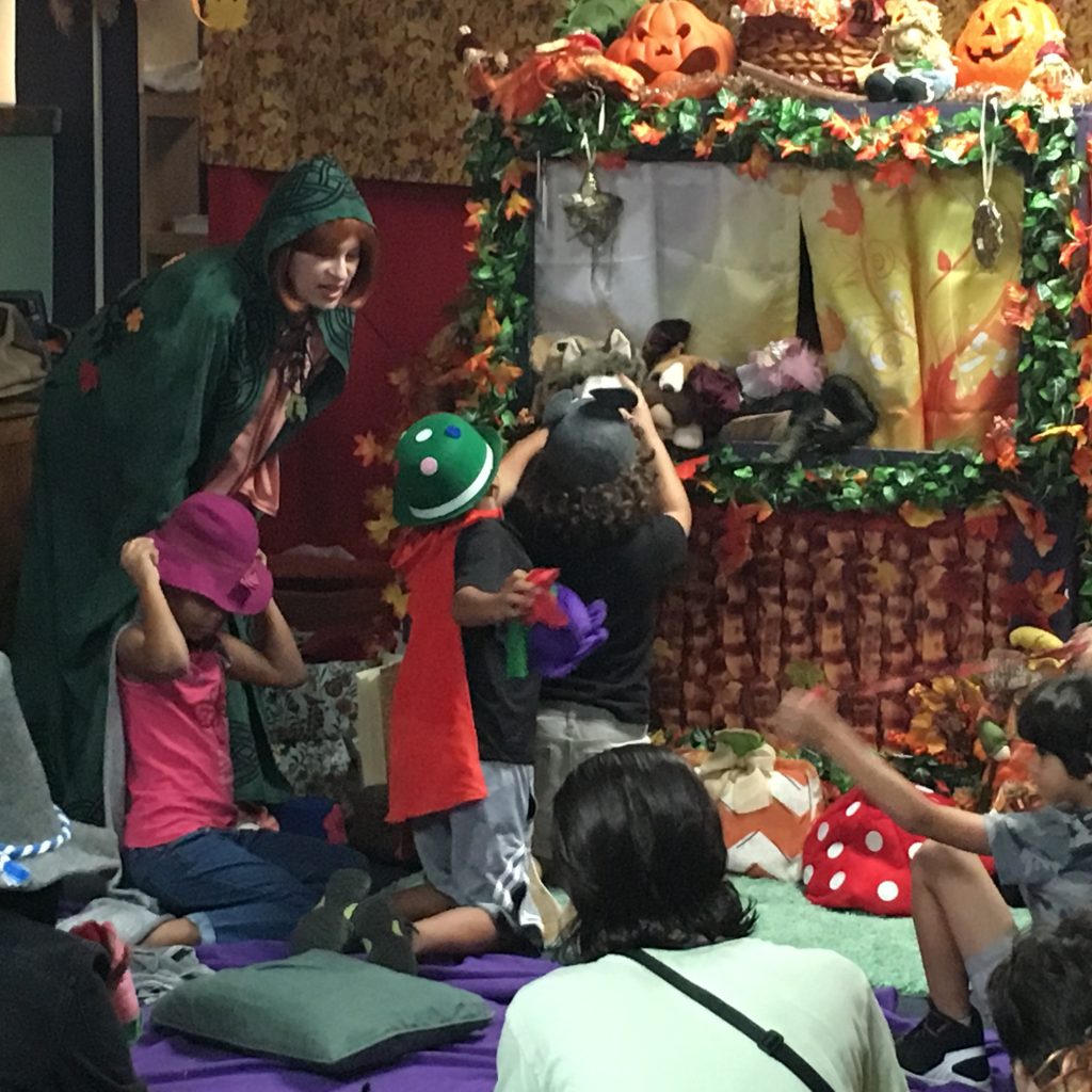 A member in costume is interacting with the children at the Children's Library Puppet Show.