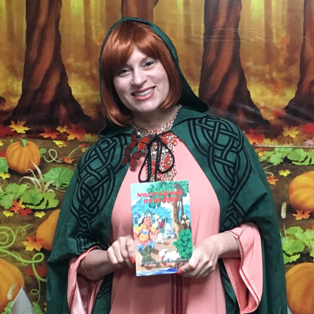 A woman is holding up a copy of a book while in costume portraying the main character of the book.