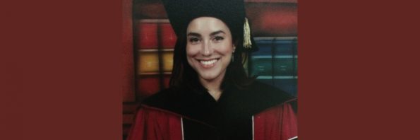 María Quintero Aguiló in her graduation robe smiling for the camera.