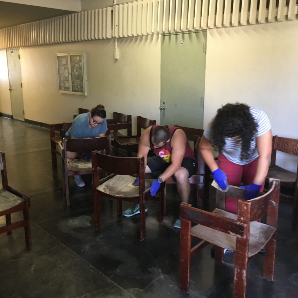 English Department's students cleaning chairs in the hall.