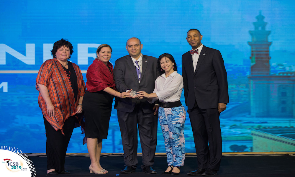 La doctora Moraima De Hoyos-Ruperto y la estudiante Jahannie Torres Rodríguez reciben el premio por el mejor artículo científico en la categoría de América del Norte y del Sur en el ICSB 2019 en Egipto. (Foto cortesía de ICSB)