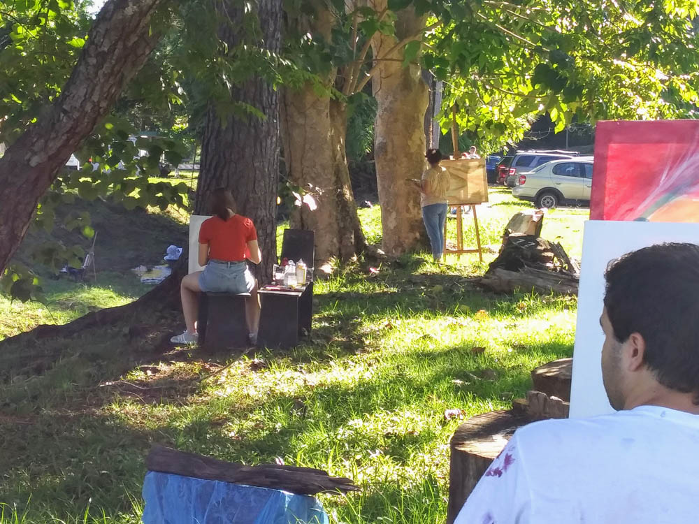 Estudiante pintando frente a Taller de Artes