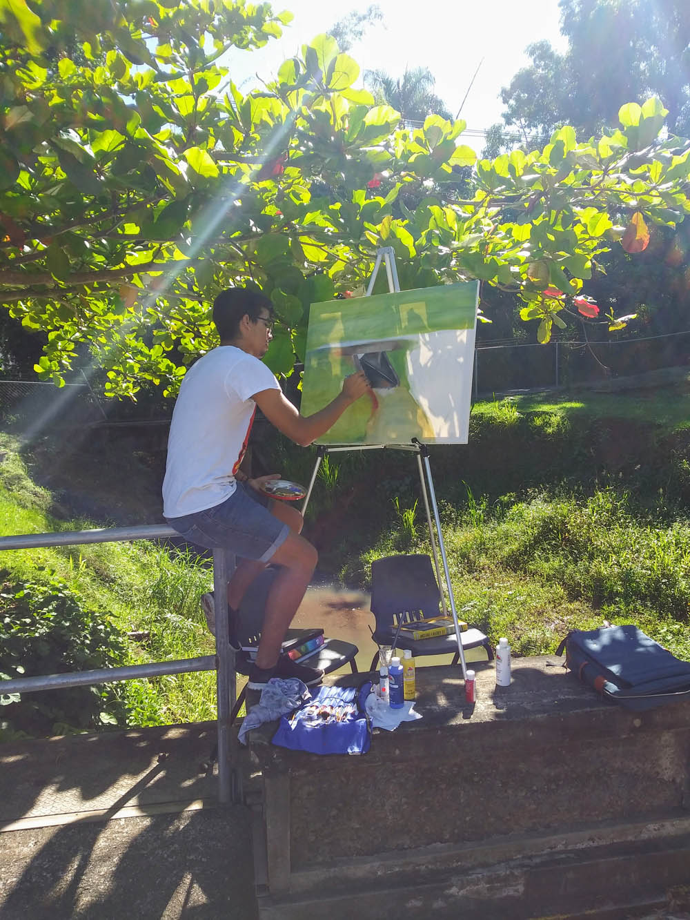 Estudiante pintando frente a Taller de Artes