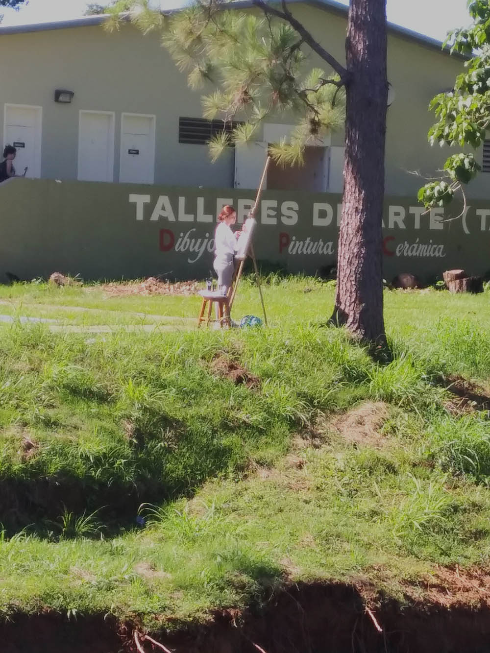 Estudiante pintando frente a Taller de Artes