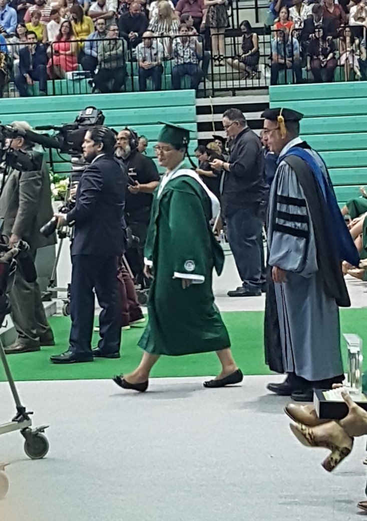 Estudiante Zoé Orench, acompañada por el Dr. Juan José Sánchez a recibir la medalla del Departamento de Humanidades