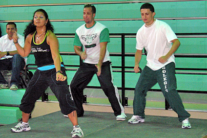 La instructora Mayda González, acompañada por el estudiante Adam Rivera, a la izquierda y otro de los participantes en la clase de zumba.