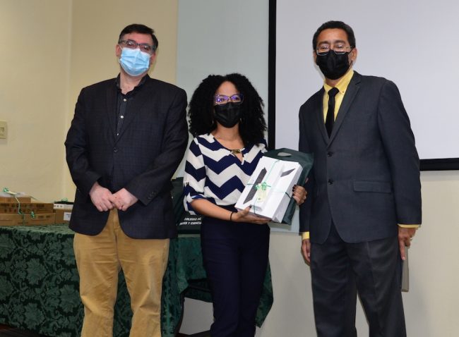 La doctora Irmarie Cruz López, de Psicología, recibe un equipo electrónico. Le acompañan los doctores Fernado Gilbes, decano (a la derecha) y Matías Cafaro, decano asociado (a la izquierda). Foto Carlos Díaz/Prensa RUM Nuevo profesorado