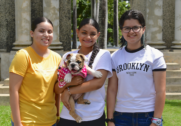 Las estudiantes de nuevo ingreso del RUM, desde la izquierda: Alexa Irizarry Vargas, Yamilet Gómez Marte y Karellen Velázquez Rivera, junto a la mascota Jane, son las primeras becadas por la Fundación CEIBA. (Foto por Carlos Díaz/Prensa RUM)