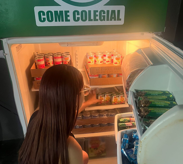 Portada Voluntaria de la Asociación Come Colegial surte la Nevera con alimentos para el estudiantado del Recinto Universitario de Mayagüez.