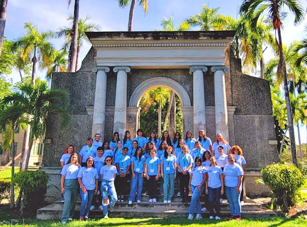 Portada Grupo de jóvenes participantes en el campamento Zirconia frente al pórtico colegial.