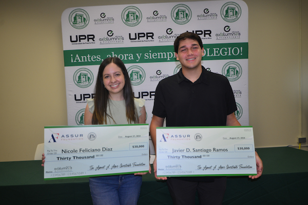 Portadita Nicole Feliciano Díaz y Javier D. Santiago Ramos muestran los cheques de las primeras becas que ganaron de la Fundación Azmat A. Assur.