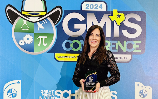Portadita La doctora Claribel Acevedo Vélez con su premio Luminary Award. De fondo, el logo de Great Minds in STEM.